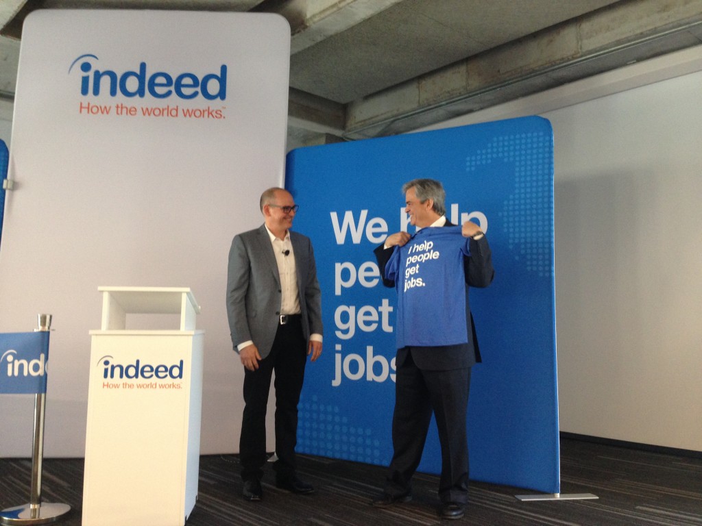Indeed's President Chris Hyams gives Austin Mayor Steve Adler an Indeed company shirt.