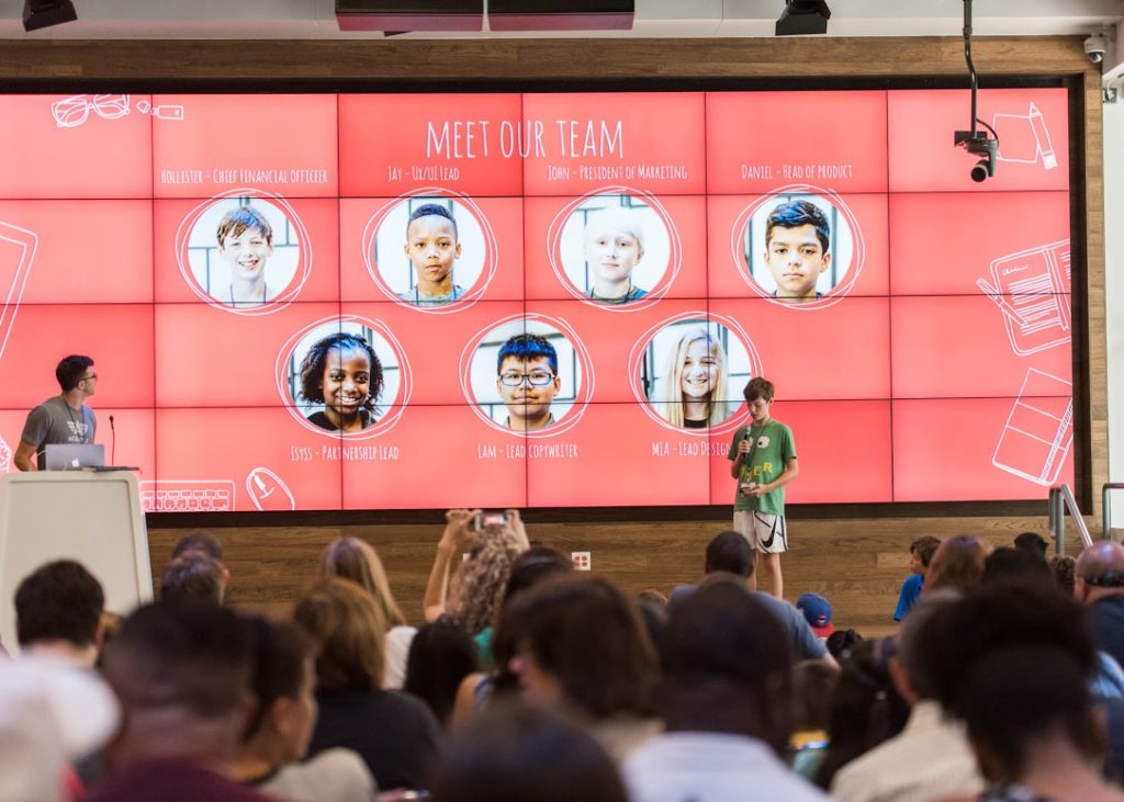 At Hello World Demo Day, a student introduces his team members.  Courtesy photo by Erika Rich. 